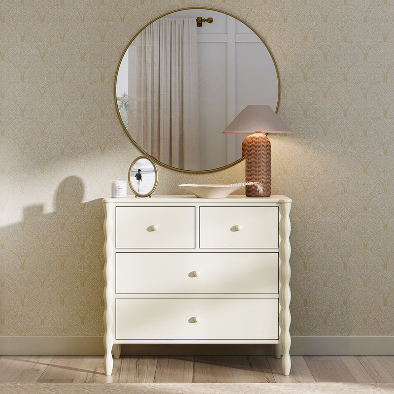 Cream four-drawer dresser with twisted legs beneath a round gold mirror, rattan table lamp, decorative bowl and framed photo — modern farmhouse entryway or bedroom decor