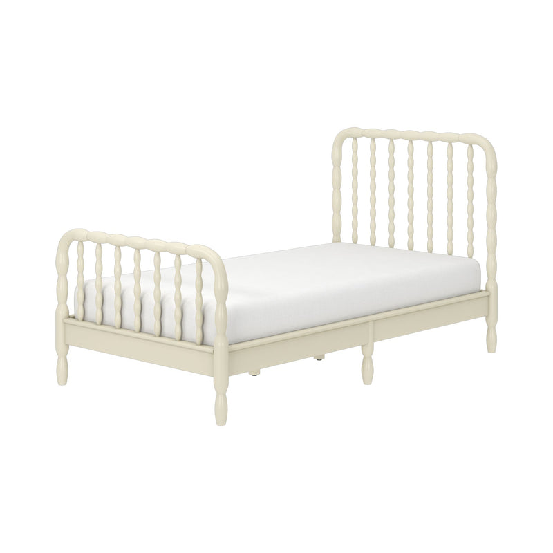 Cream wooden spindle bed frame with turned headboard and footboard and white mattress, farmhouse-style vintage design