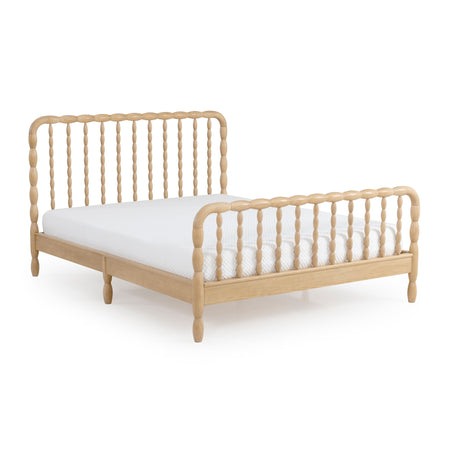 Light natural-finish wooden spindle bed frame with rounded turned posts, matching spindle headboard and footboard, low platform base and white mattress on a white background