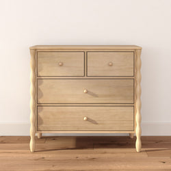 Light natural wood dresser with four drawers and turned legs on hardwood floor, minimalist Scandinavian chest for bedroom storage