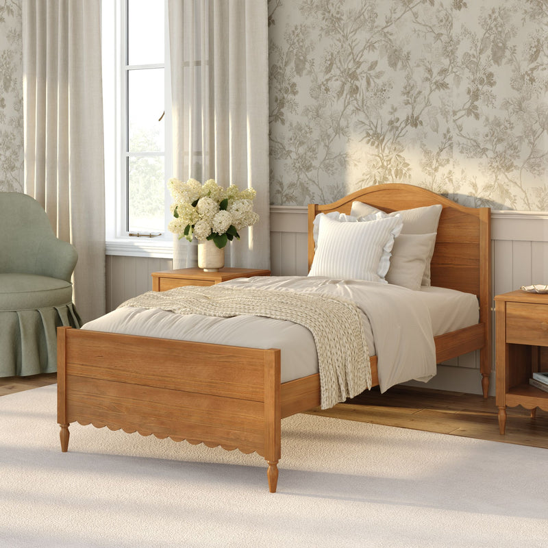Cozy neutral farmhouse bedroom with wooden bed, cream linen bedding and knit throw, floral wallpaper, linen curtains, natural light and hydrangea bouquet on bedside table