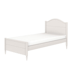 White wooden twin bed frame with arched headboard, scalloped footboard, turned legs and mattress