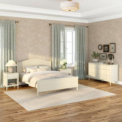 Cozy neutral farmhouse bedroom interior with cream wooden bed, matching nightstands and dresser, light green curtains, beige floral wallpaper, area rug on hardwood floor, table lamp, potted plant and framed bird art