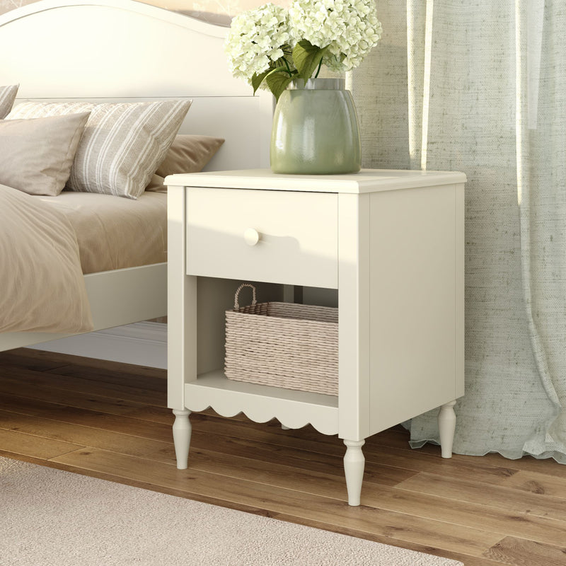 Cream white bedside table nightstand with drawer, wicker basket and green vase of white hydrangeas in cozy neutral bedroom decor