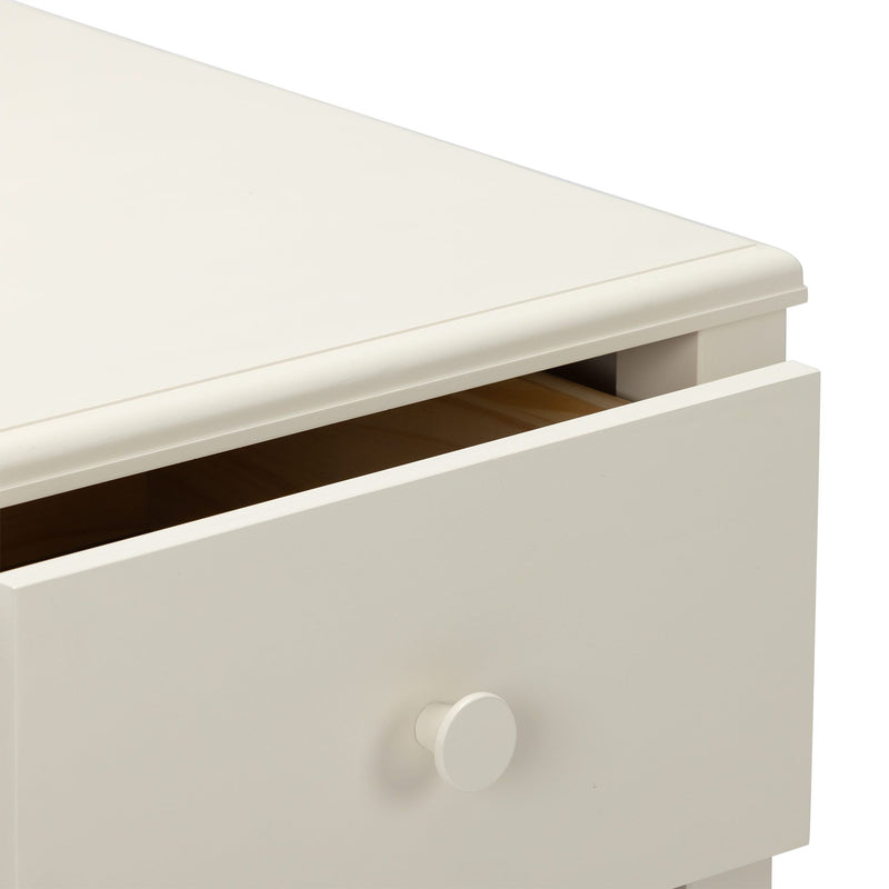 Close-up of cream white wooden dresser with slightly open drawer, round knob and smooth top edge, modern minimalist bedroom storage furniture