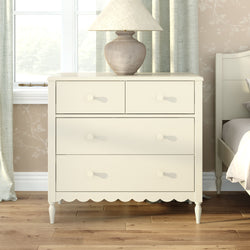 Cream wooden dresser with four drawers and beige ceramic table lamp on hardwood floor in a neutral modern farmhouse bedroom — bedroom storage furniture