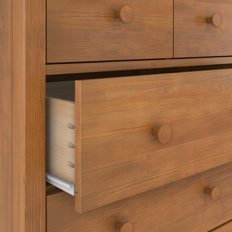 Wooden chest of drawers with partially open drawer showing dovetail joints and metal slide, natural wood grain finish and round wooden knobs
