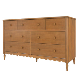Oak-finish wooden dresser with multiple drawers, round wooden knobs, scalloped apron and turned legs — mid-century farmhouse bedroom storage chest