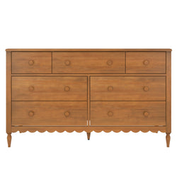 7-drawer honey-brown wood dresser with round wooden knobs, scalloped apron and turned legs — farmhouse bedroom storage chest