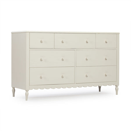 Cream white wooden dresser with multiple drawers, round knobs, turned legs and scalloped apron — vintage-inspired bedroom storage