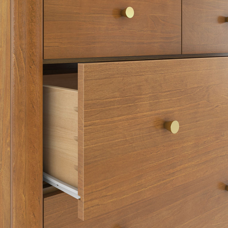 Wooden dresser drawer partially open with brass knob, dovetail joints and metal drawer slides, modern bedroom storage furniture