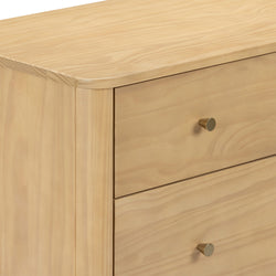 Close-up of light pine dresser drawers with natural wood grain, rounded top edge and brass knob