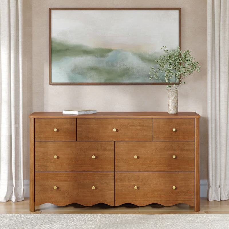 Mid-century wooden dresser with brass knobs, framed abstract landscape art, marble vase with baby’s breath and light linen curtains — minimalist neutral bedroom decor