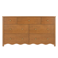 Warm oak-finish wooden dresser with multiple drawers, round brass knobs and scalloped apron, mid-century modern bedroom storage chest