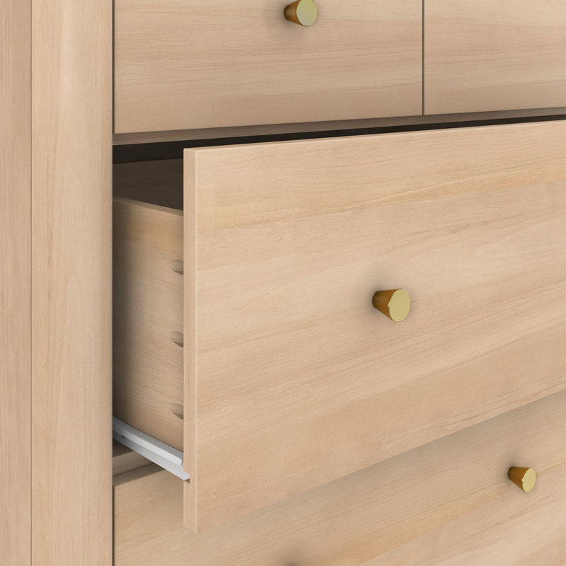 Close-up of light maple wood dresser with partially open drawer and gold knobs, modern bedroom storage furniture
