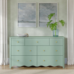 Mint green dresser with yellow knobs in modern interior, framed coastal abstract art, monstera plant in glass vase and neutral curtains