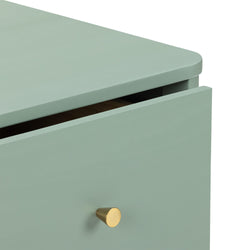 Close-up of mint green wooden dresser drawer with brushed brass cone knob — modern minimalist bedroom chest of drawers detail