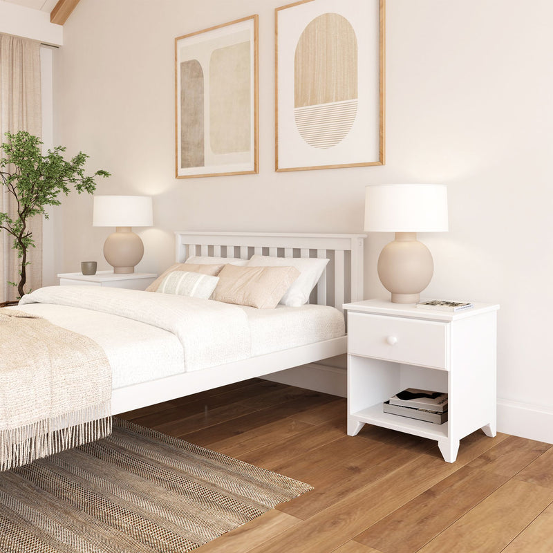 Modern minimalist bedroom with white bed frame, wooden flooring, and decorative plant.