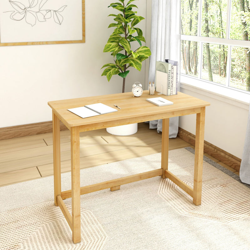 Minimalist wooden desk in a bright home office with plant and natural light.