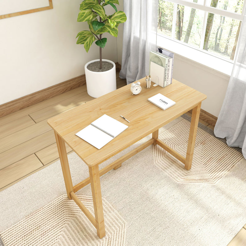 Minimalist home office setup with wooden desk, potted plant, and natural light through window.