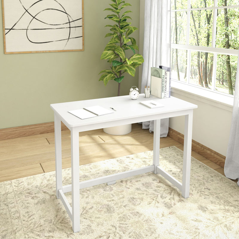 Modern white desk in a bright home office with large window, green plant, and wall art.