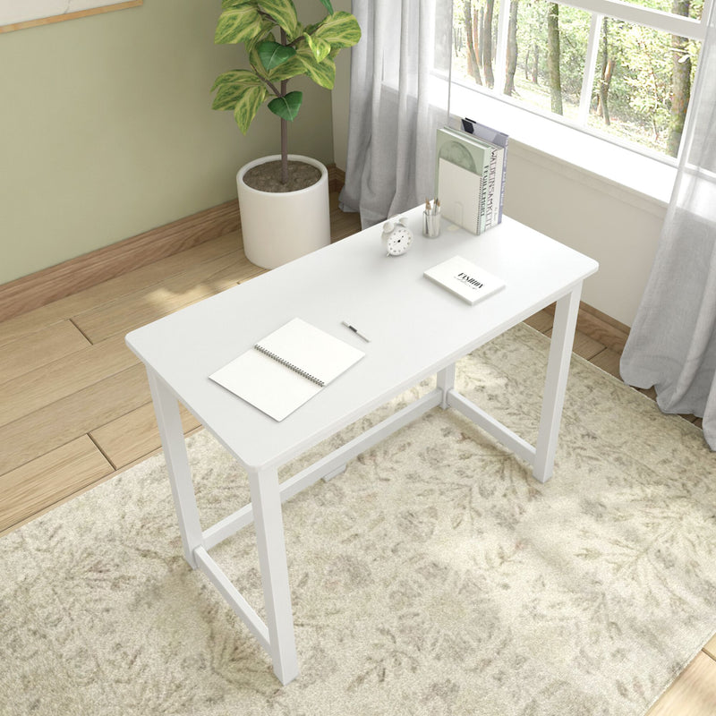 Minimalist white desk in bright home office with plant and natural light.