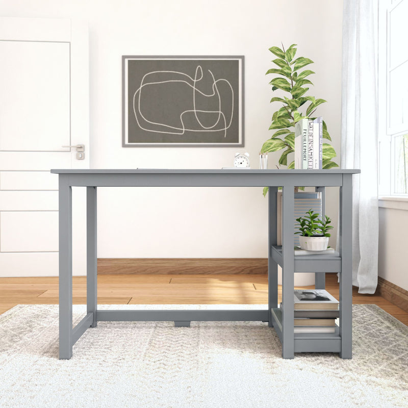 Minimalist home office with modern gray desk, shelving for books and plants, natural light through window, and abstract wall art.