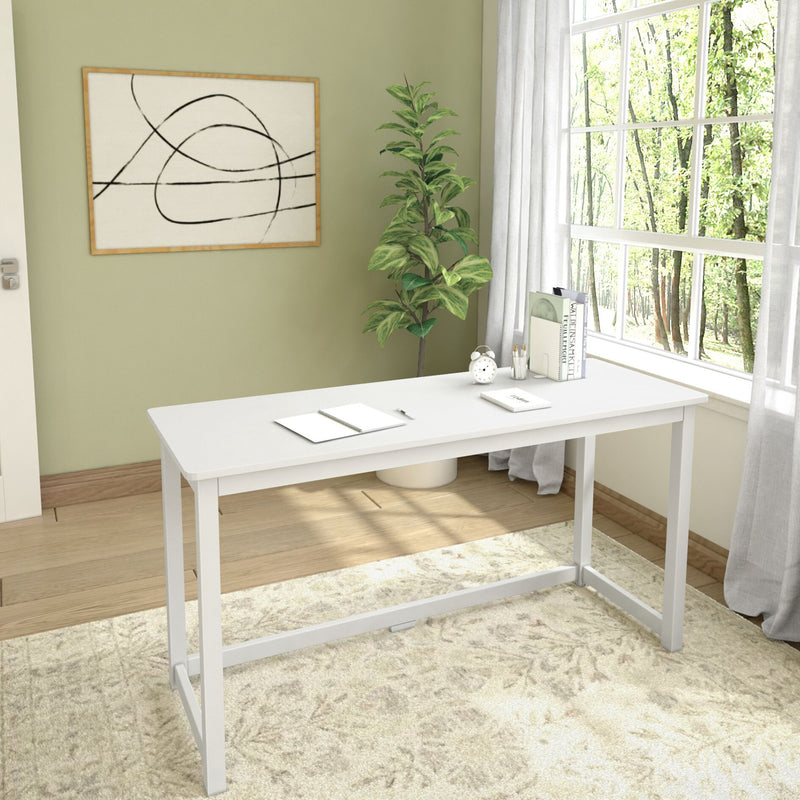 Modern minimalist home office with white desk, indoor plant, abstract wall art, and large window providing natural light.