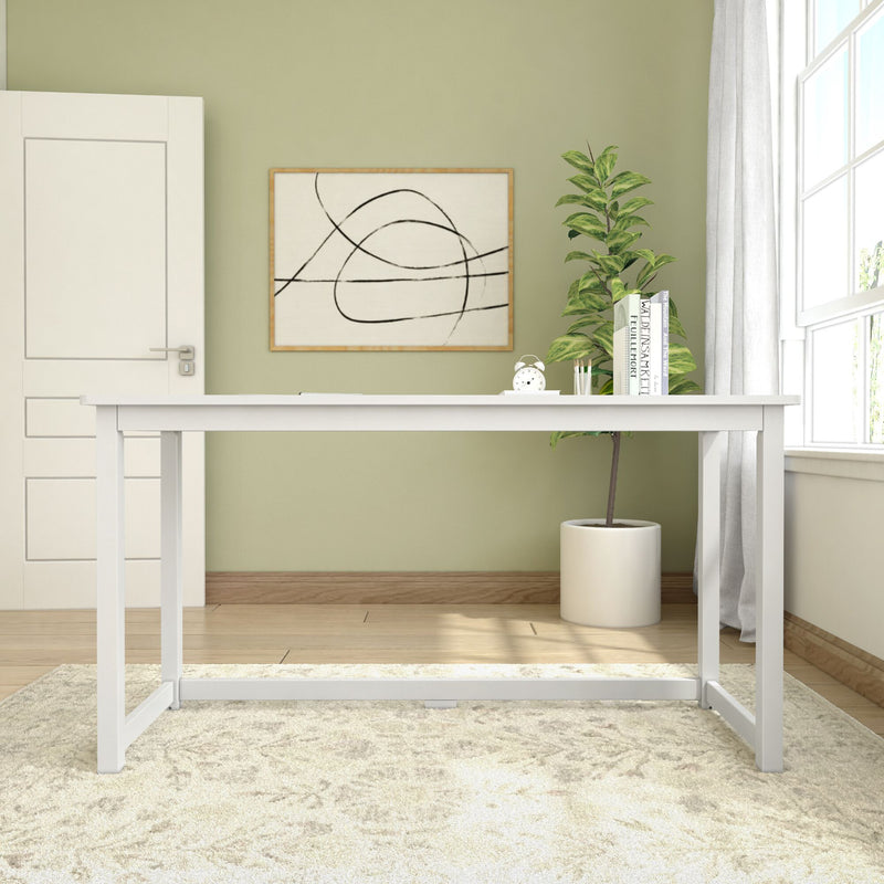 Minimalist home office setup with a white desk, abstract wall art, and a potted plant against a light green wall.