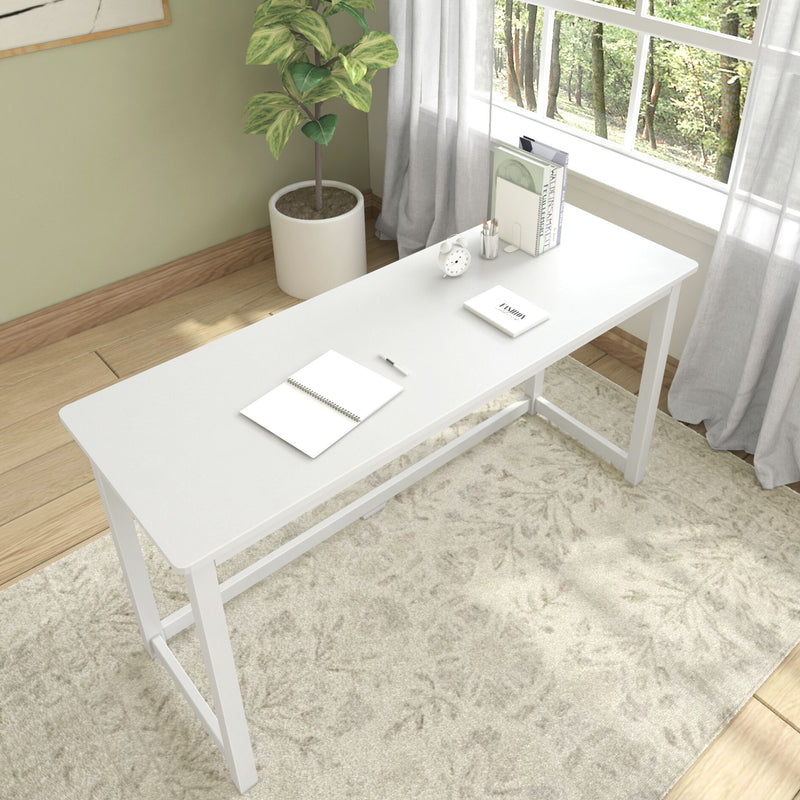 Modern white desk in a bright home office with plant and books near a large window.