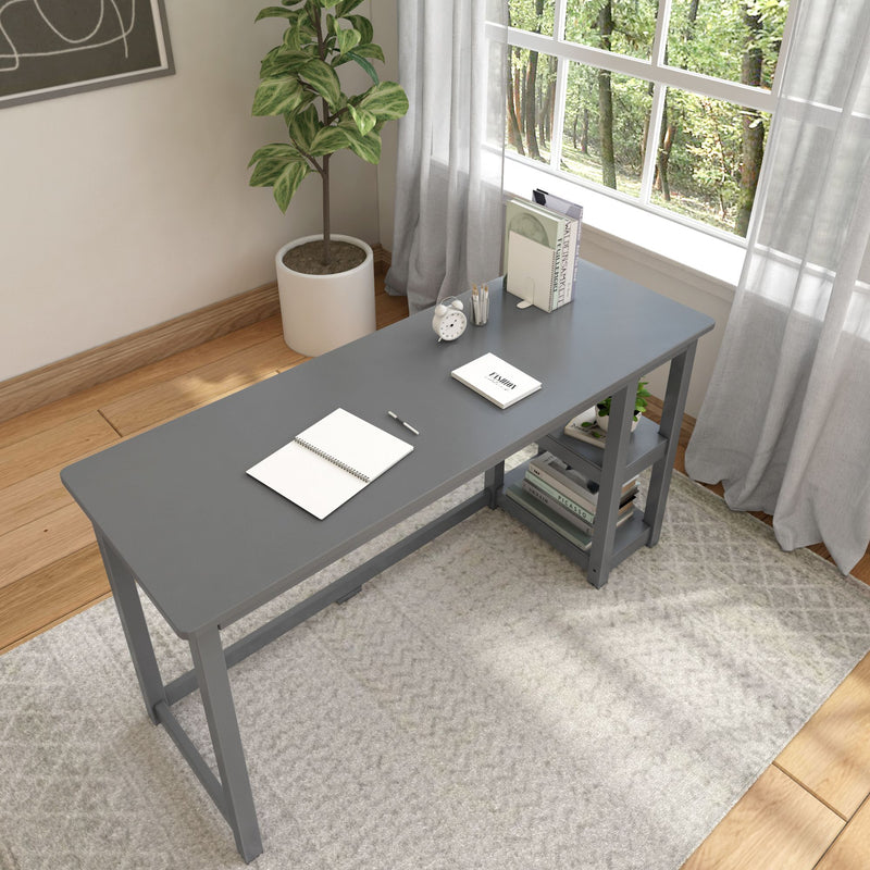Gray minimalist desk by a window with plants and office supplies in modern home office setting.