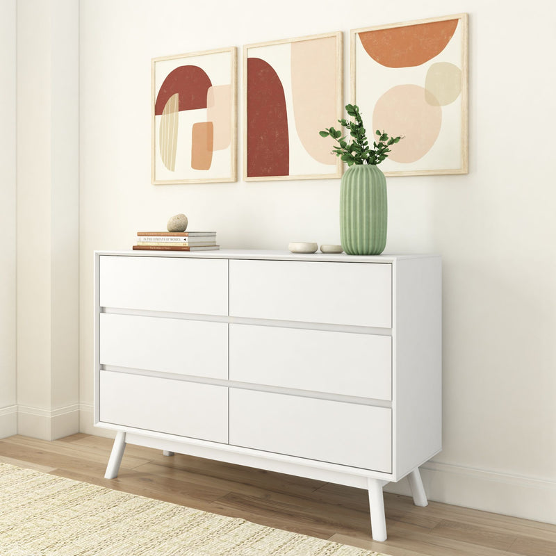 White modern dresser with minimalist decor and abstract wall art in a contemporary living room.