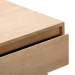 Natural wood desk corner with open drawer.