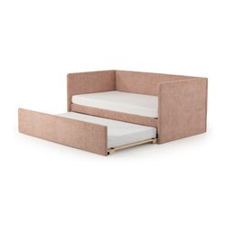 Pink velvet upholstered corner daybed with pull-out trundle and twin mattresses on white background