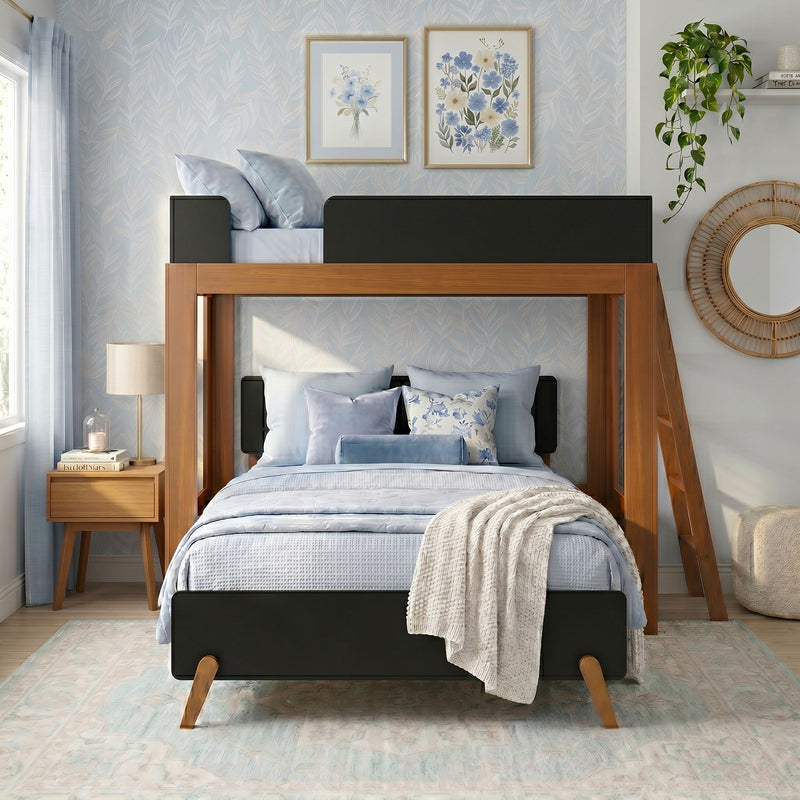 Modern coastal-style bedroom with wooden loft bunk bed, light blue bedding and pillows, floral framed art, rattan mirror, nightstand lamp and hanging plant