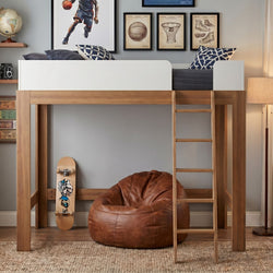 Modern wooden loft bed in kids' bedroom with ladder, skateboard, brown leather bean bag, globe and framed sports wall art