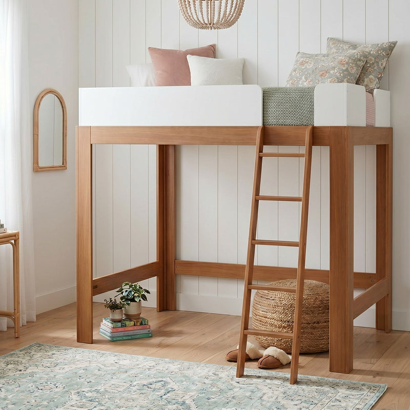 Modern wooden kids loft bed with ladder in neutral bedroom, white guardrail, pastel pillows, floral cushion, woven pouf and area rug