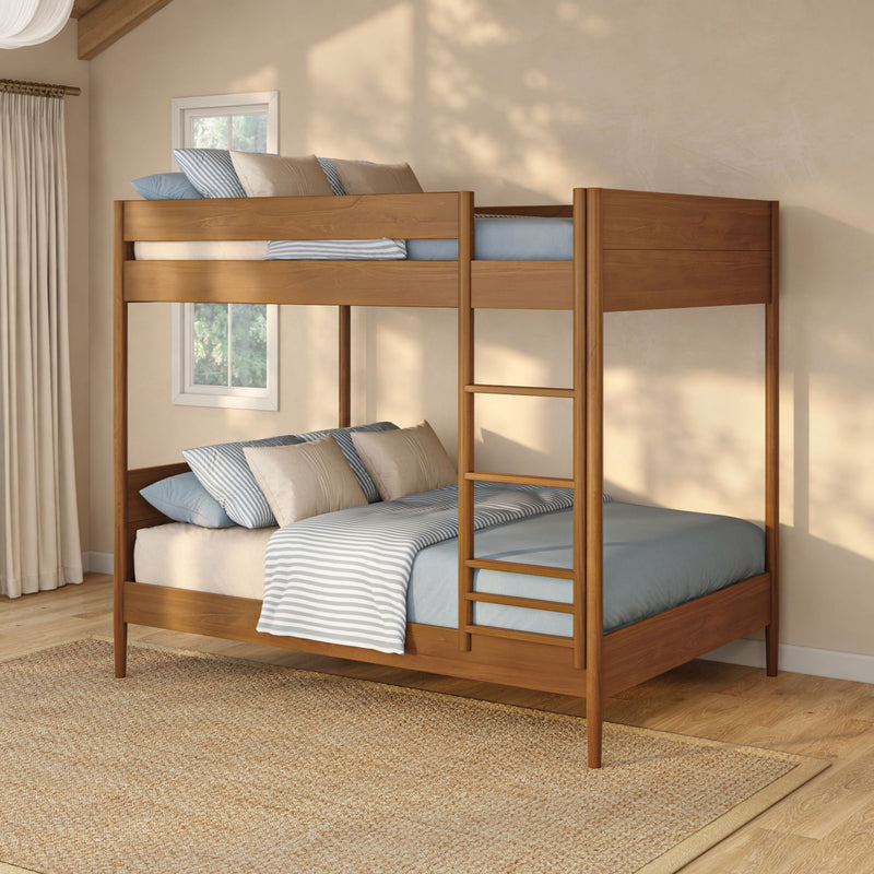 Solid wood twin-over-full bunk bed with built-in ladder, blue-striped bedding and beige pillows in a sunlit neutral bedroom