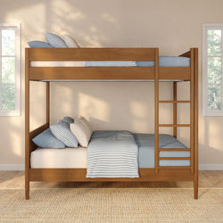 Solid wood twin-over-twin bunk bed with ladder and blue striped bedding in a bright sunlit modern kids' bedroom